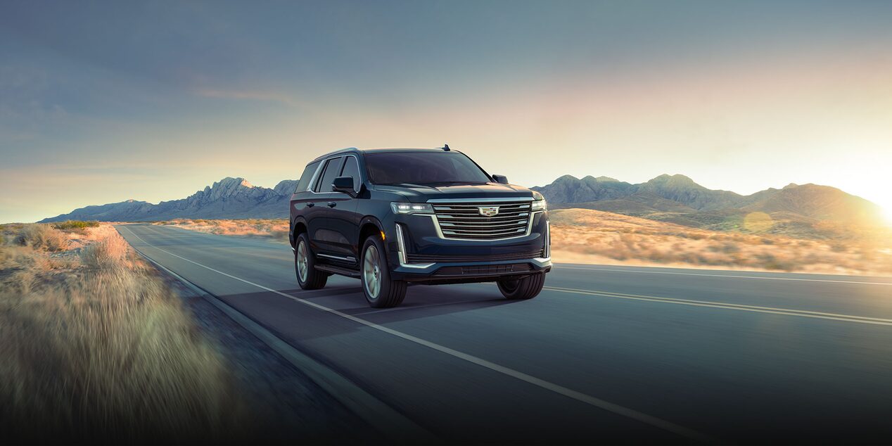 Front view of the 2024 Escalade driving on the road.