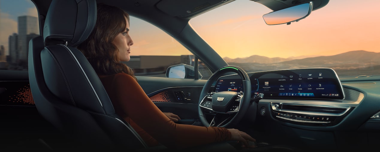 Rear passenger's view of the front interiors of the 2025 Cadillac LYRIQ with a person on the driver's seat.