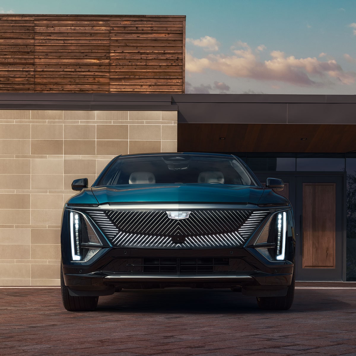 Vue de face de la Cadillac LYRIQ 2025 stationnée devant un bâtiment.