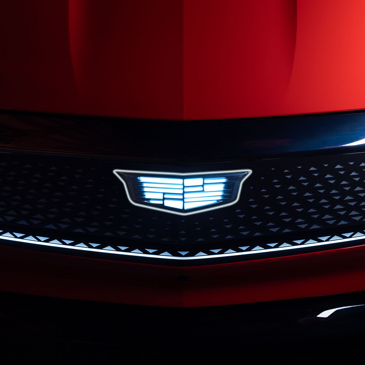 Close up view of the illuminated front grille on the 2025 Cadillac OPTIQ electric SUV.