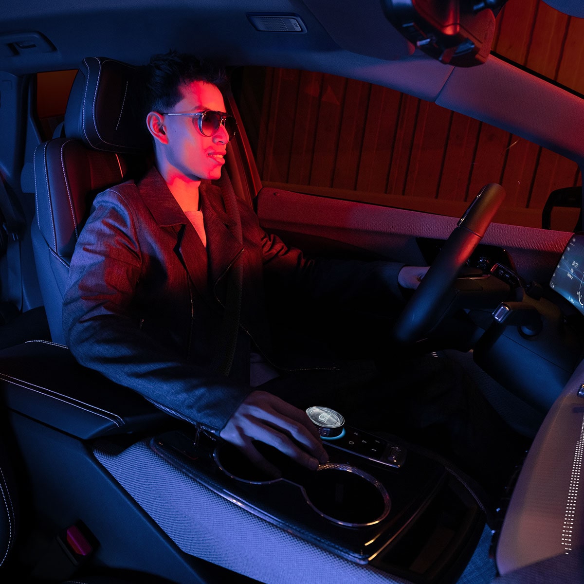 A person manning the driver's seat inside the 2025 Cadillac OPTIQ electric SUV.