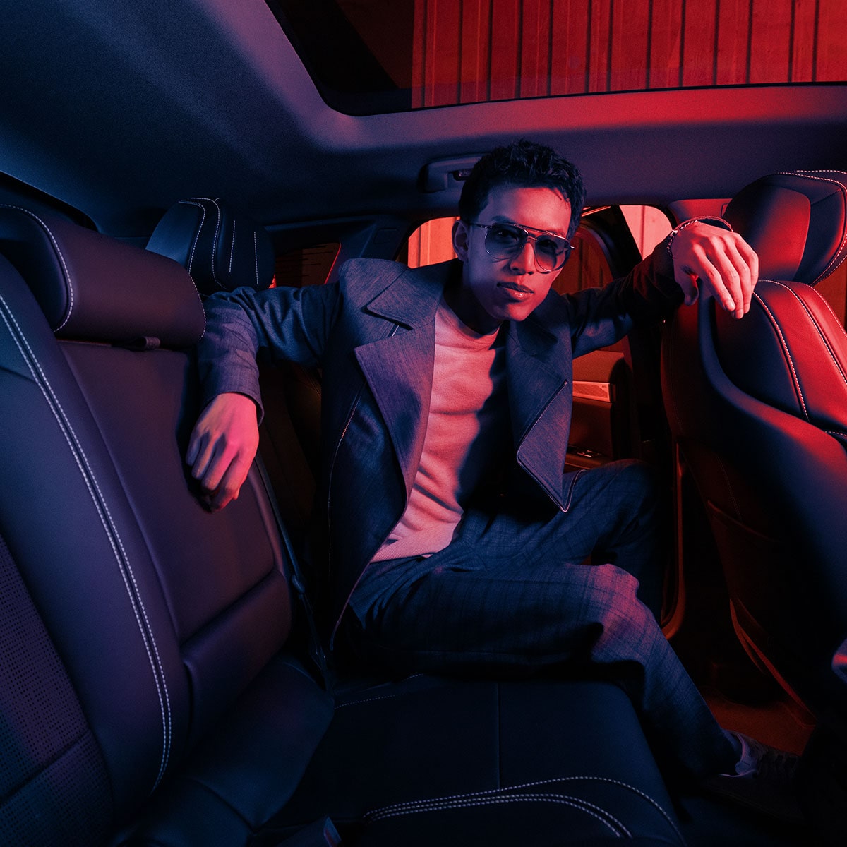 A person seated in the rear seats of the 2025 Cadillac OPTIQ electric SUV.