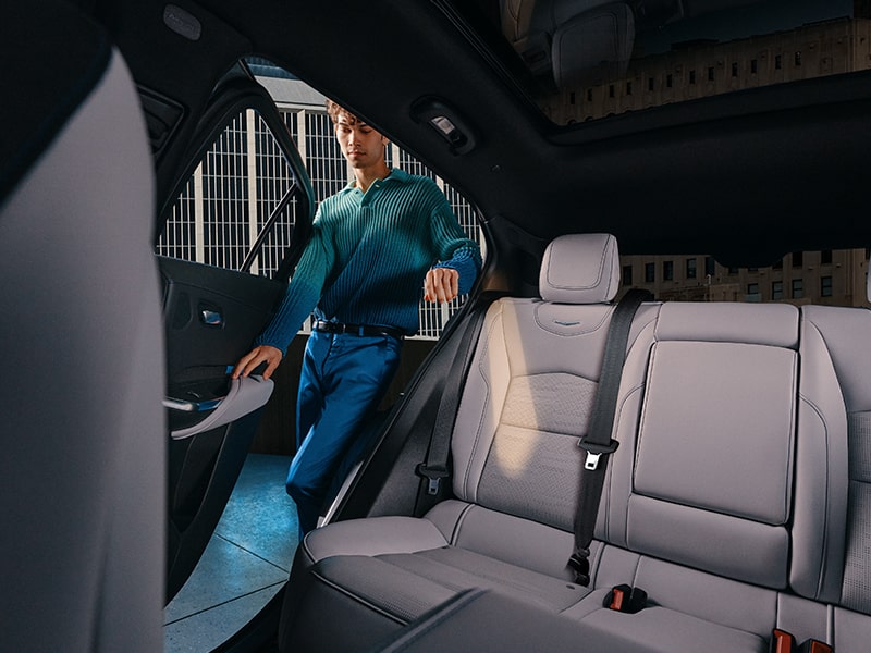 A person opening the rear passenger door of the 2025 Cadillac XT4.