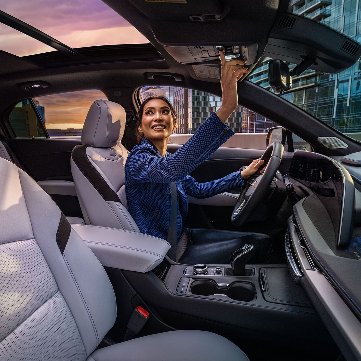 Vue latérale de l’habitacle côté conducteur et du toit ouvrant du Cadillac XT4 2025 avec une personne assise sur le siège du conducteur. 