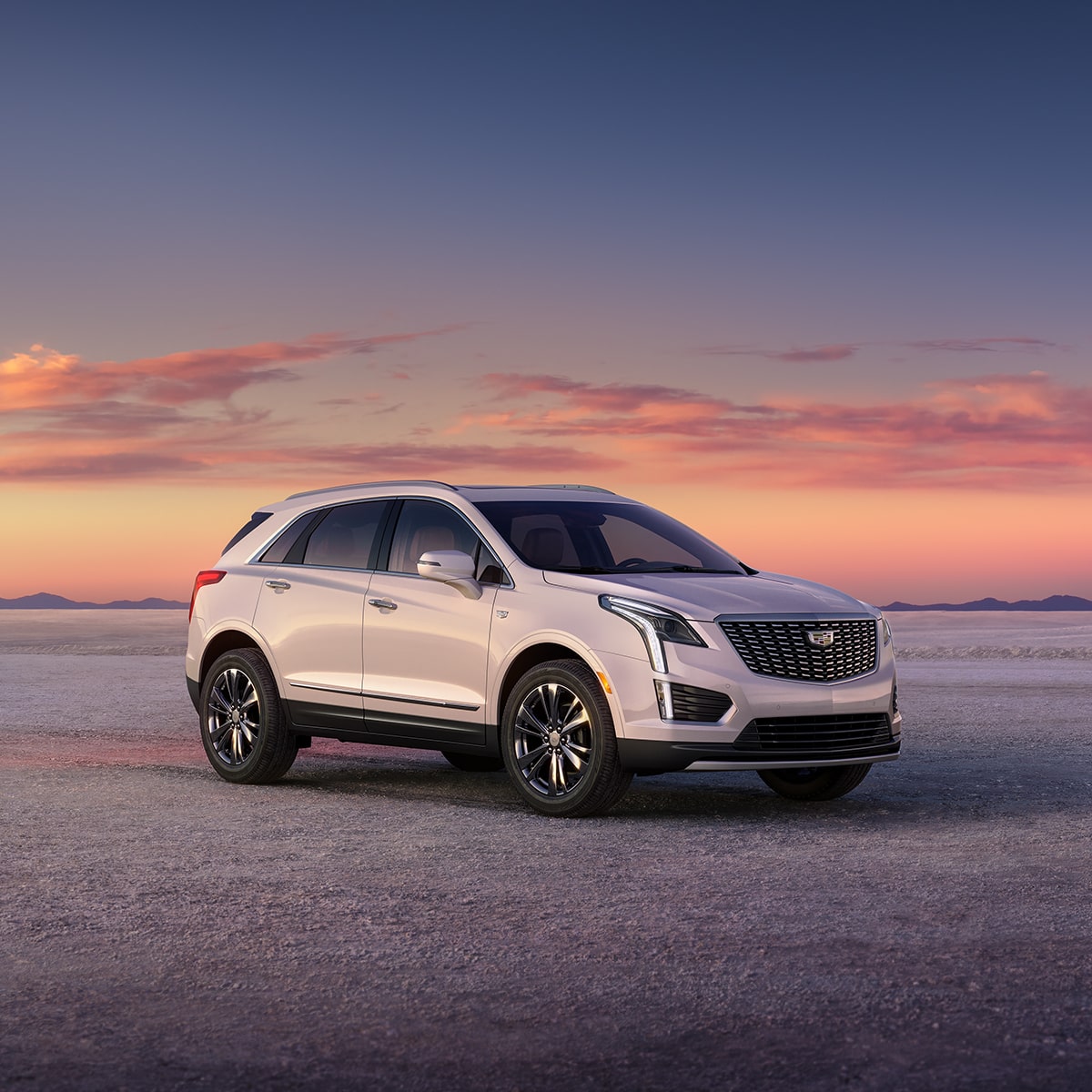 Un VUS de luxe Cadillac XT5 2025 stationné à l’extérieur au lever du soleil.