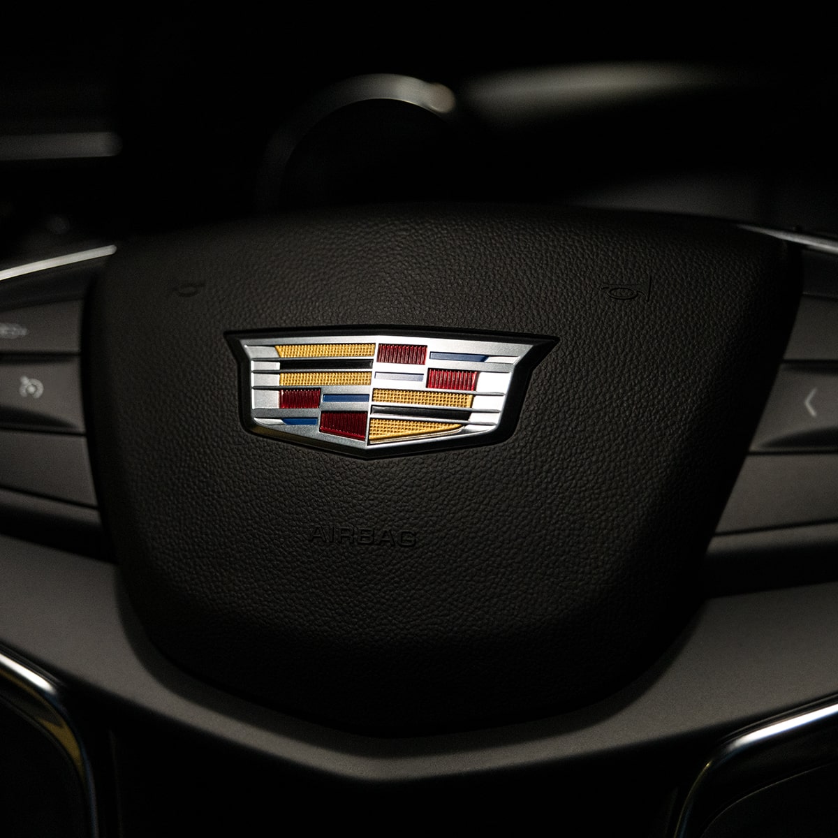 Vue rapprochée de l’emblème Cadillac sur le volant du VUS de luxe Cadillac XT5 2025.