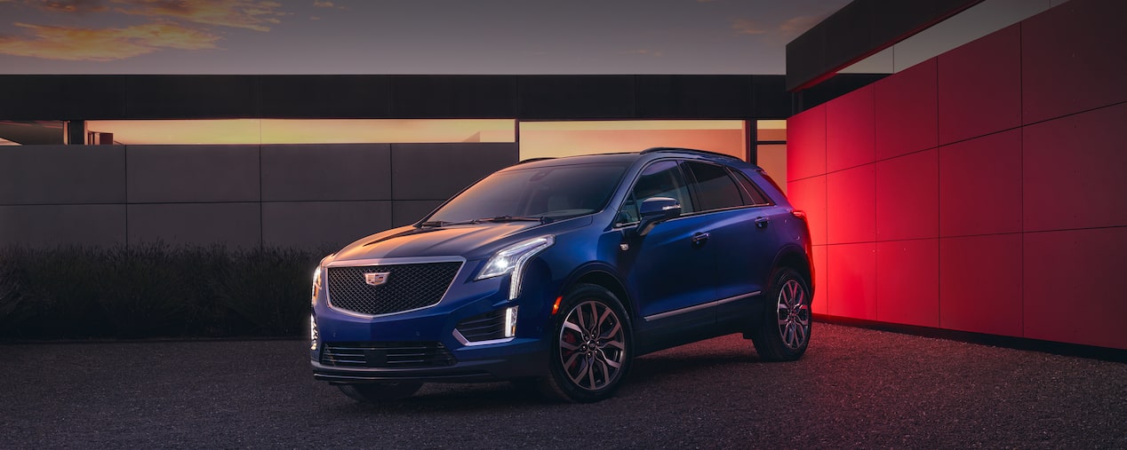 VUS de luxe Cadillac XT5 2025 stationné à côté de deux murs la nuit.