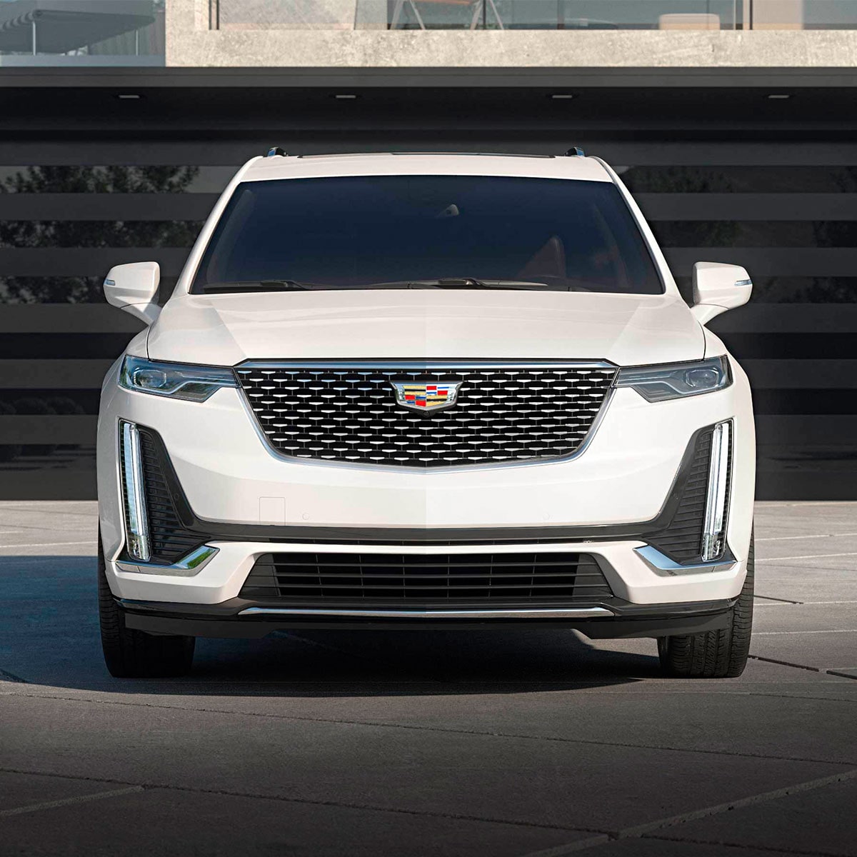 Vue avant du VUS intermédiaire 7 passagers Cadillac XT6 2025 stationné devant une maison.