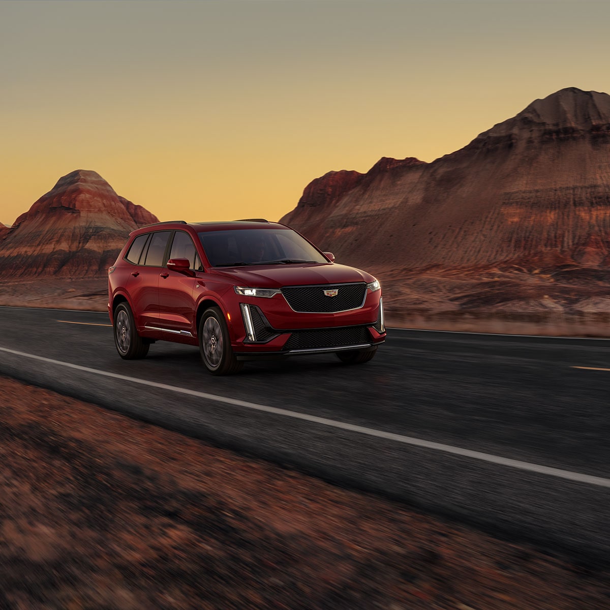 VUS intermédiaire 7 passagers Cadillac XT6 2025 en mouvement devant un canyon.