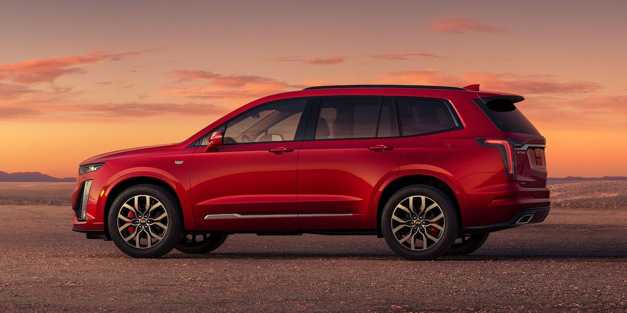 Vue latérale du VUS intermédiaire 7 passagers Cadillac XT6 2025 stationné seul à l’extérieur.