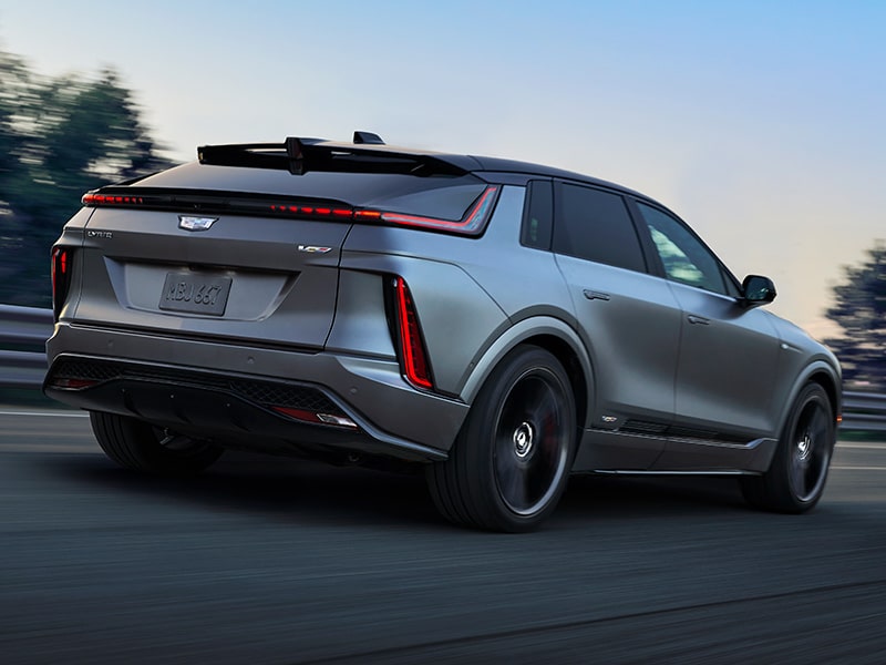 Back-side view of the 2026 Cadillac LYRIQ-V driving fast on the road.