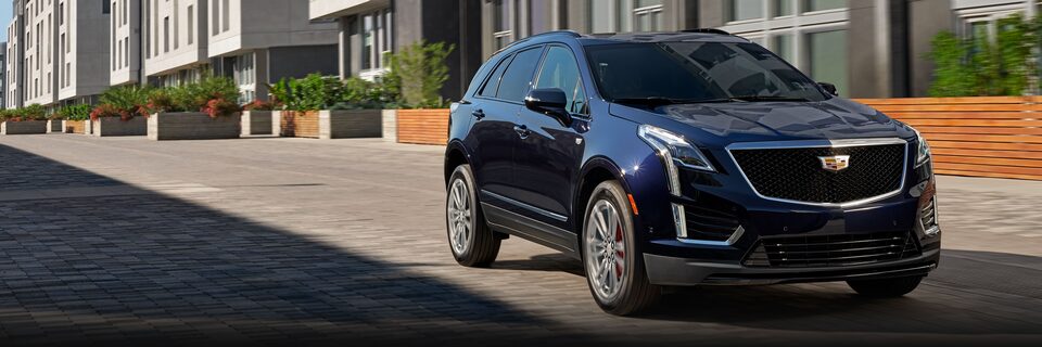 2023 Cadillac XT5 parked on the road beside a building.