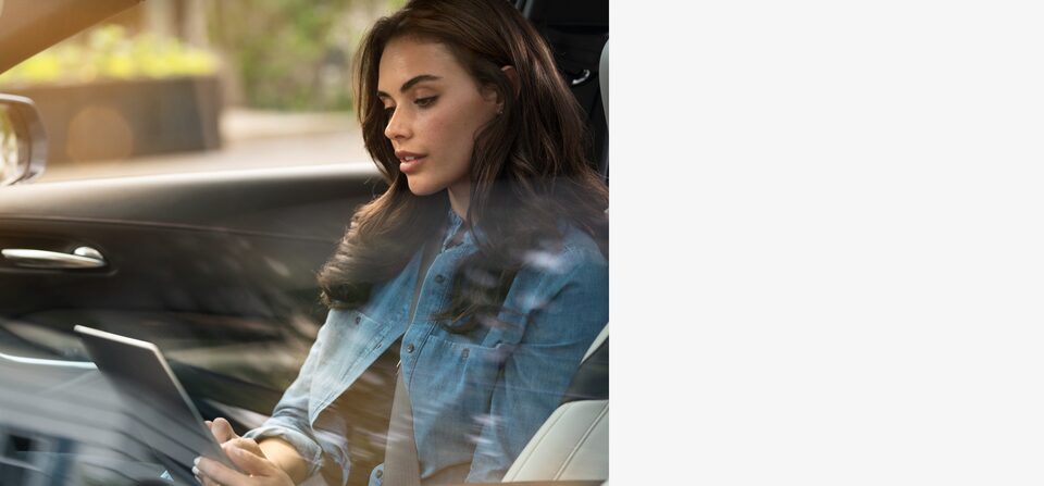 Femme dans une Cadillac utilisant les services connectés de Cadillac.