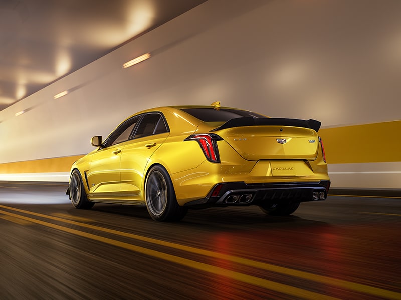 Vue latérale arrière de la berline sport de luxe Cadillac CT4-V 2025 en mouvement seule dans un tunnel.