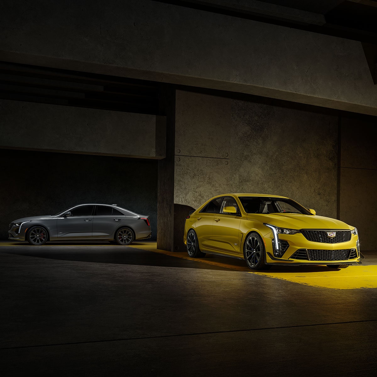 Two 2025 Cadillac CT4-V luxury sports sedan vehicles parked in a dimly-lit area.