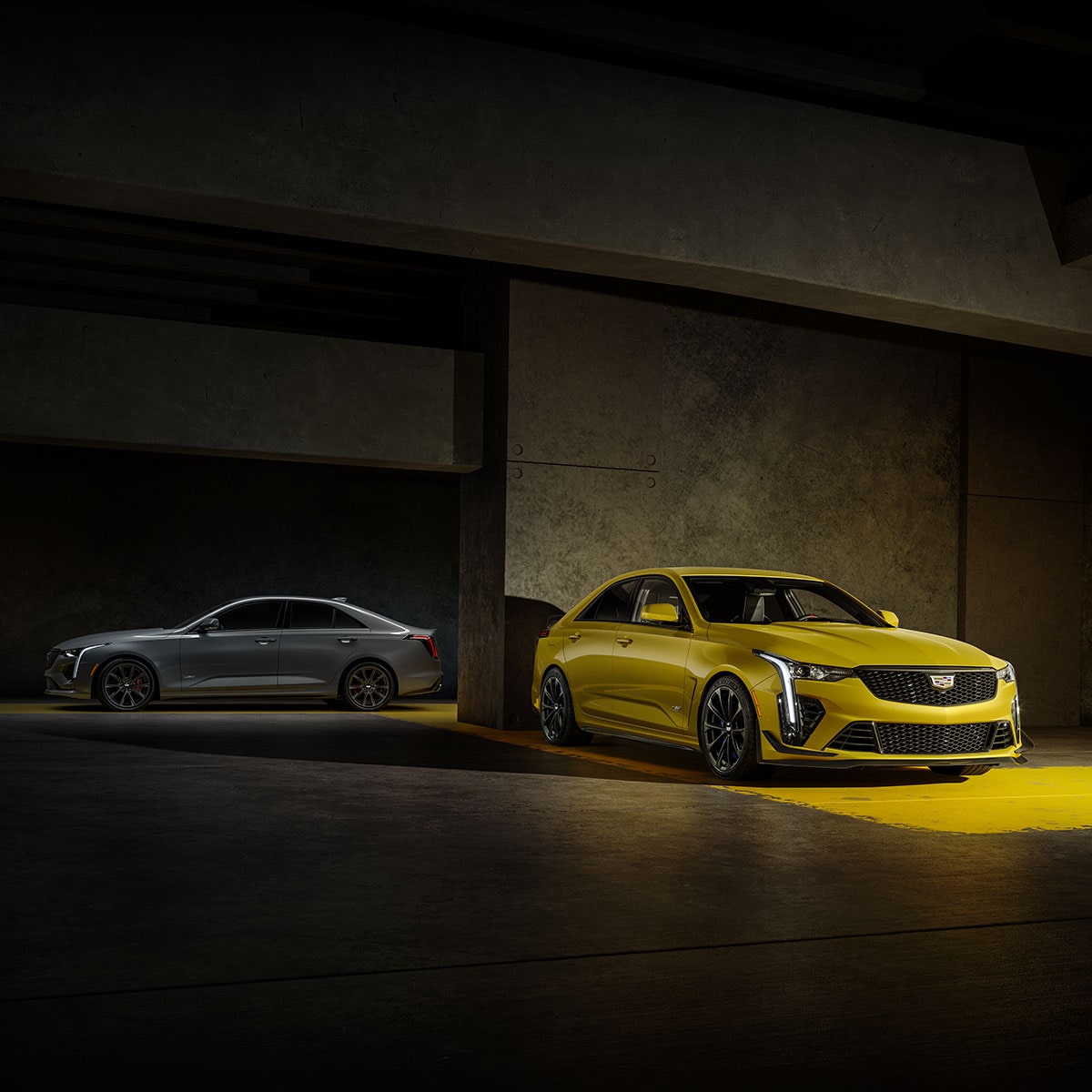Two 2025 Cadillac CT4-V luxury sports sedan vehicles parked in a dimly-lit area.