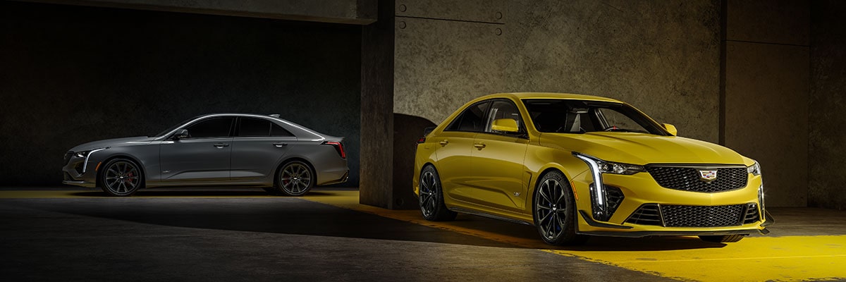 Two 2025 Cadillac CT4-V luxury sports sedan vehicles parked in a dimly-lit area.