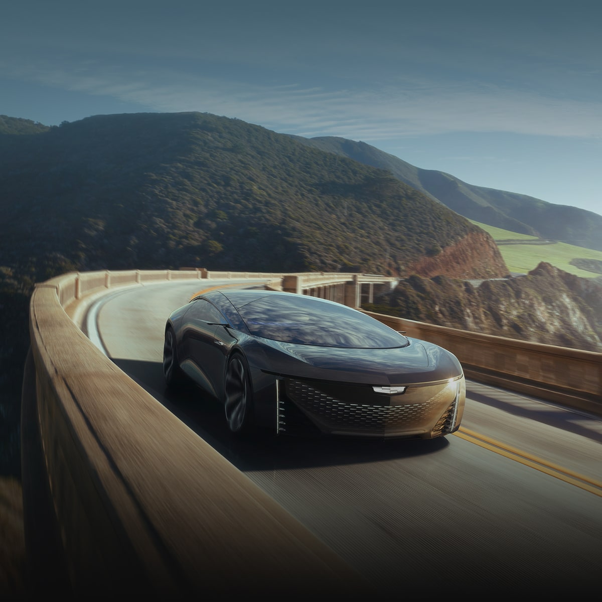 A Cadillac Concept Vehicle driving alone on a hillside road.