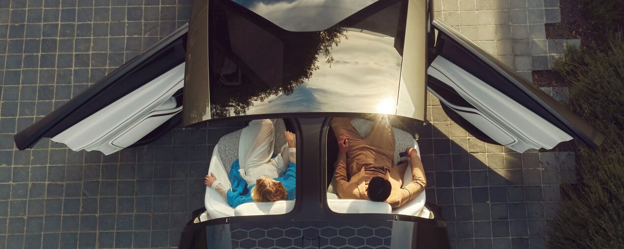 Top view of a Cadillac InnerSpace Concept Vehicle with the door opened and two people seated inside.