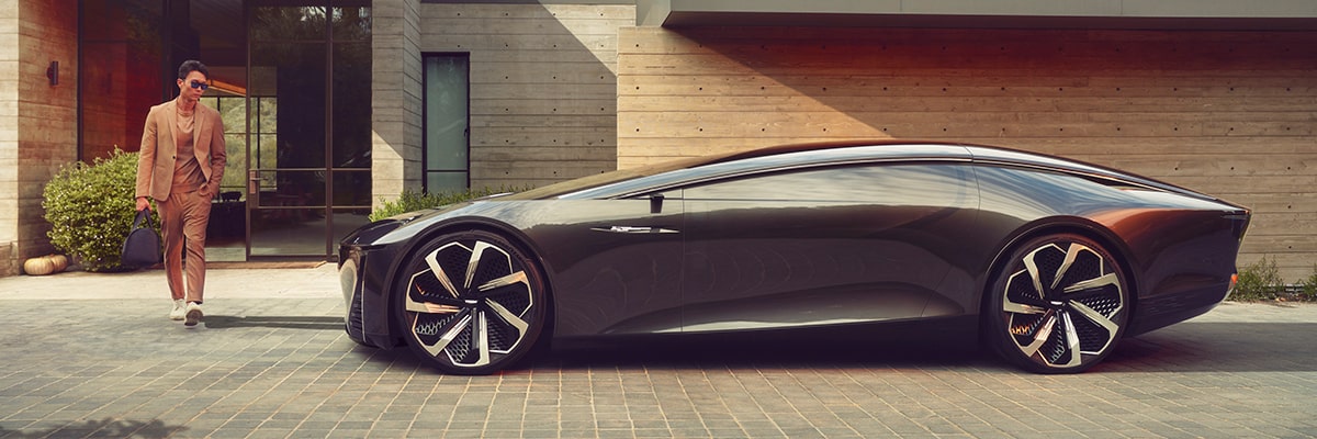 Side view of Cadillac InnerSpace Concept Vehicle parked outside a home as a person passes by.