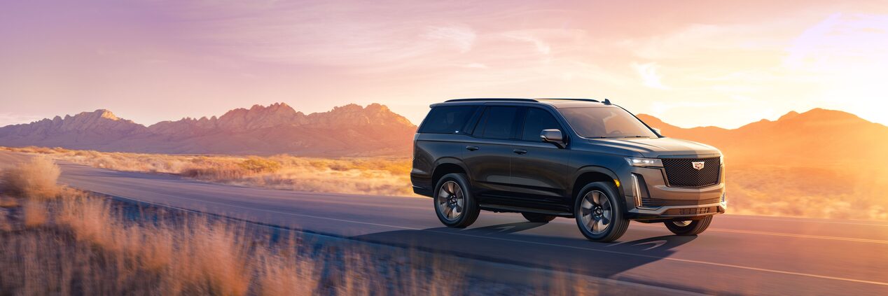 Scenic shot of the 2023 Cadillac Escalade driving on the road.