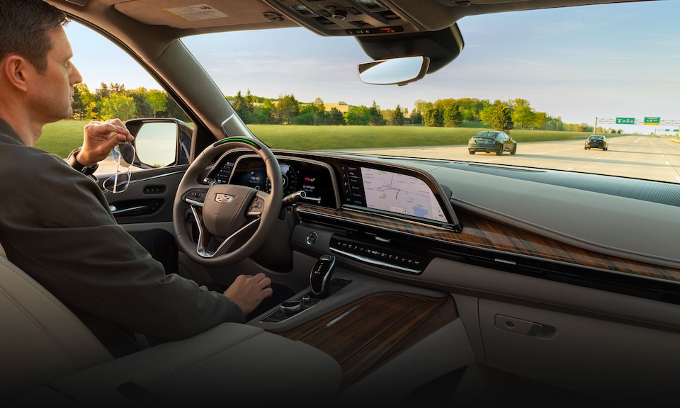 A person driving a 2023 Cadillac Escalade using the Super Cruise feature.