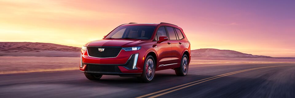 The 2024 Cadillac XT6 driving across a highway.