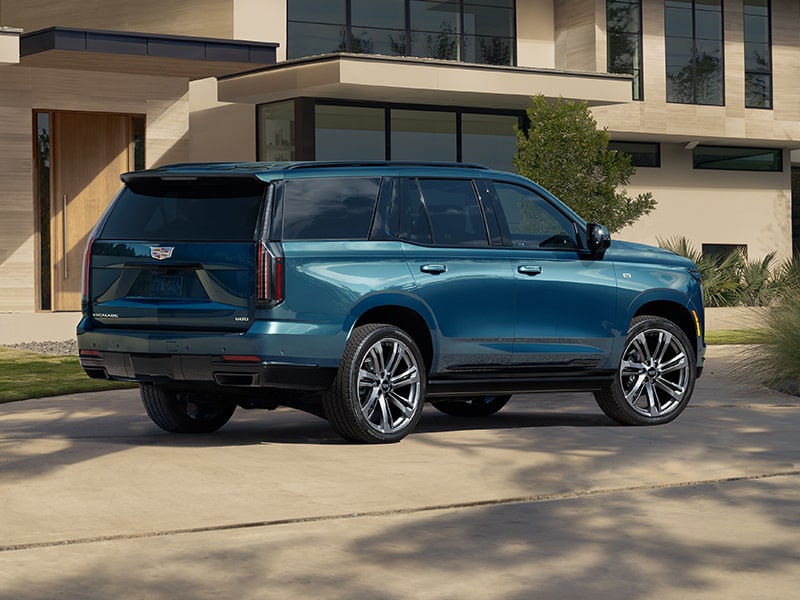Back-side view of the 2025 Cadillac Escalade parked outside a home.