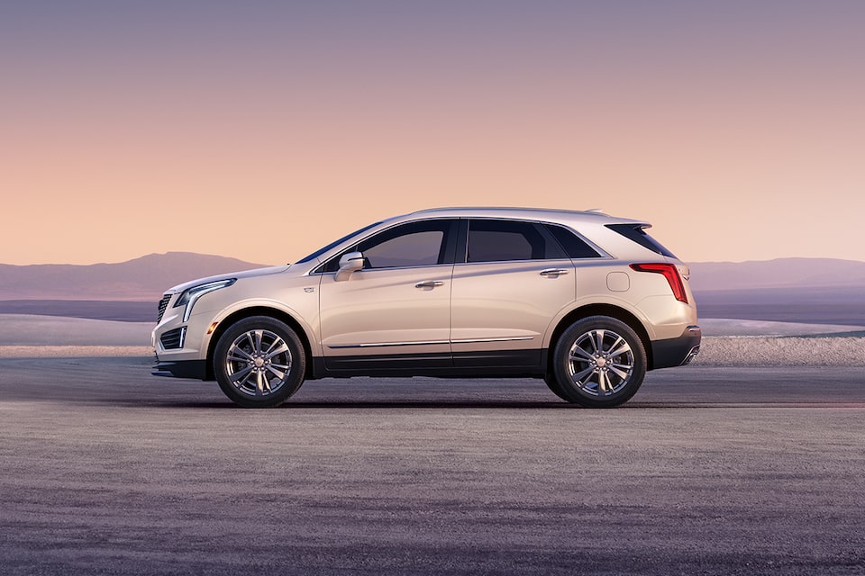 Side view of the 2026 Cadillac XT5 luxury SUV parked outdoors during sunrise.