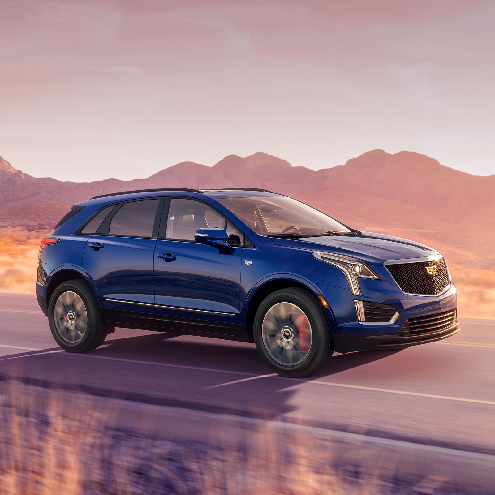 2026 Cadillac XT5 luxury SUV driving alone on a farmside road.