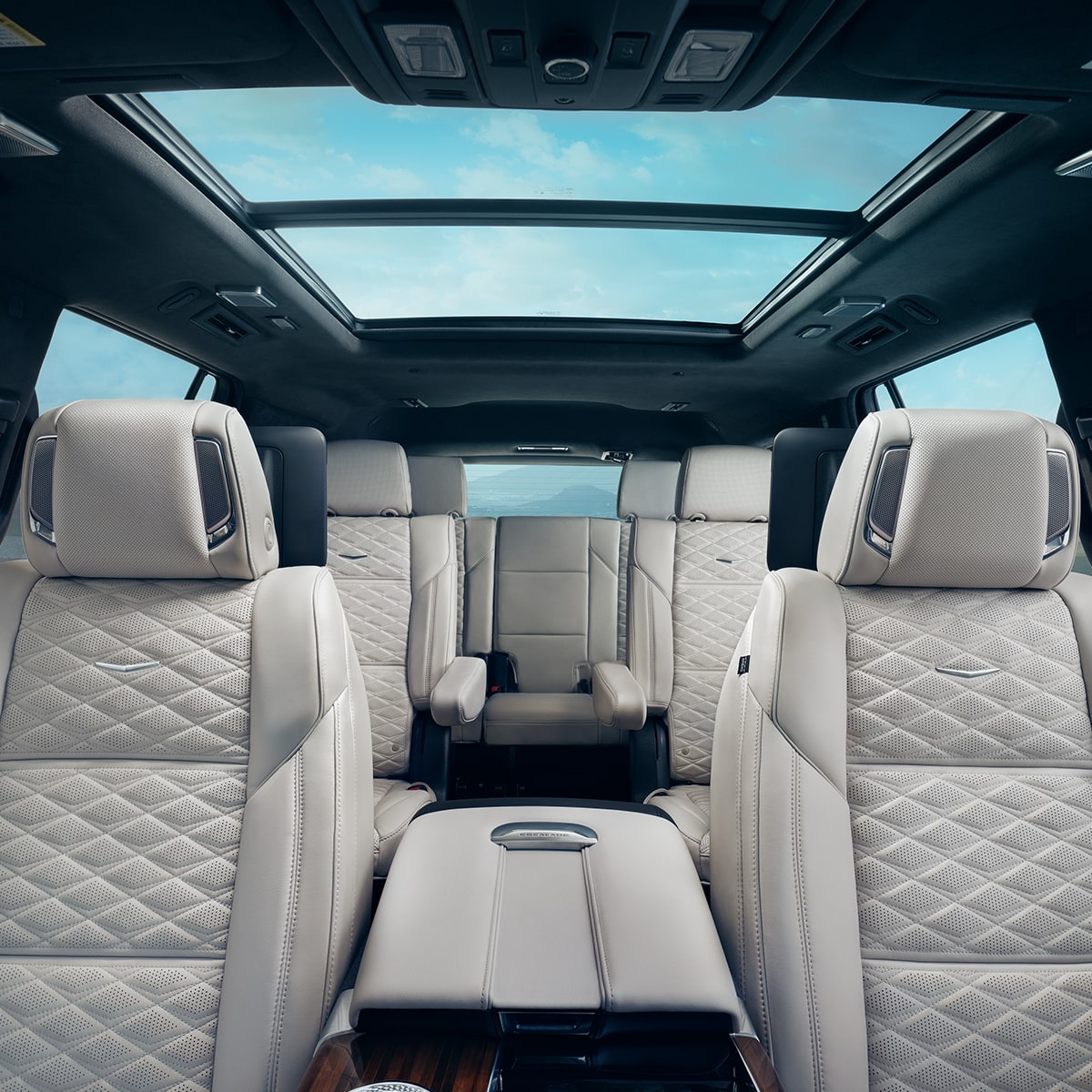 Trois rangées de sièges spacieux en cuir de couleur pâle dans le Cadillac Escalade 2027 sous un toit panoramique en verre