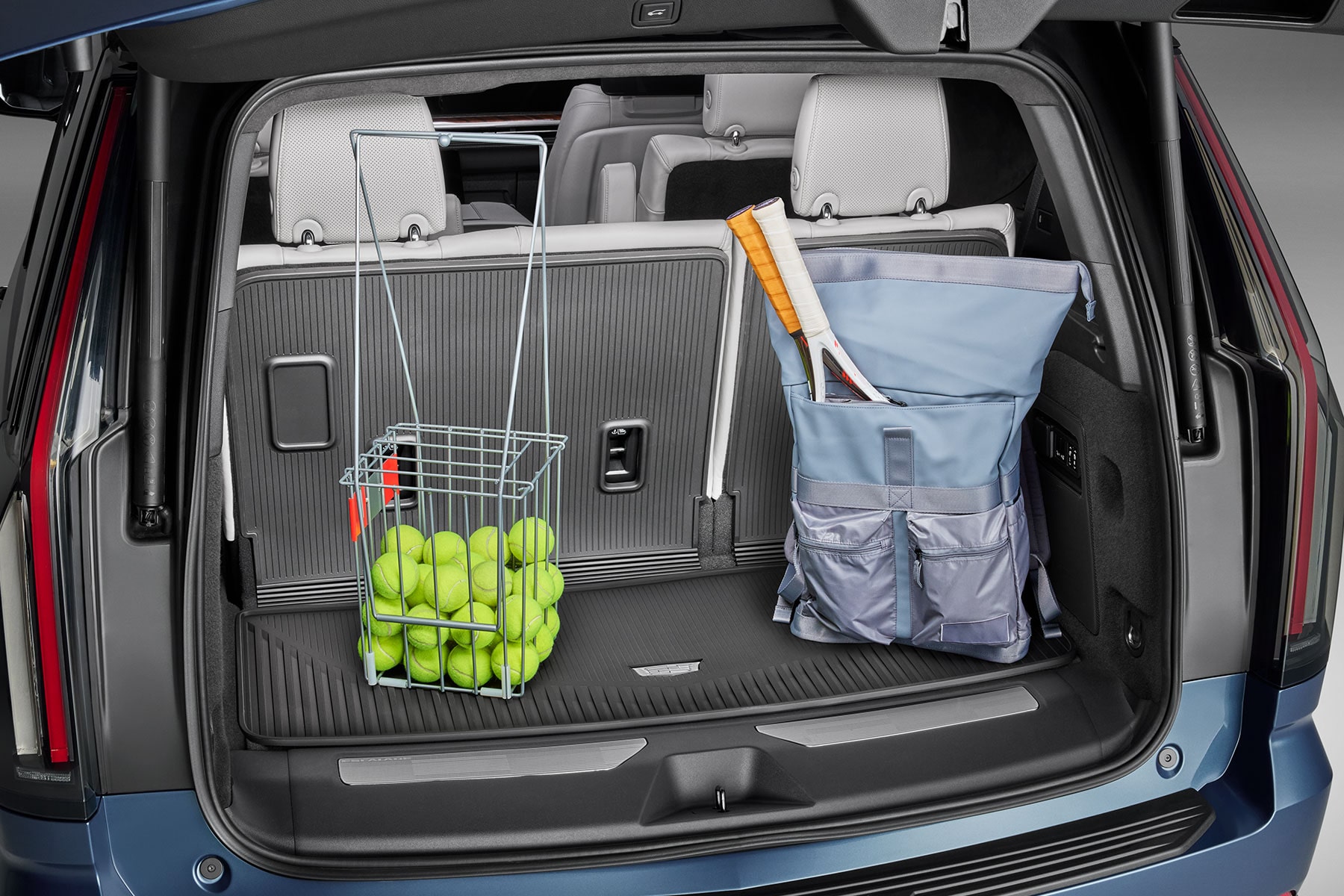 Espace de chargement spacieux du Cadillac Escalade 2027 avec un panier de balles de tennis et un sac de raquettes