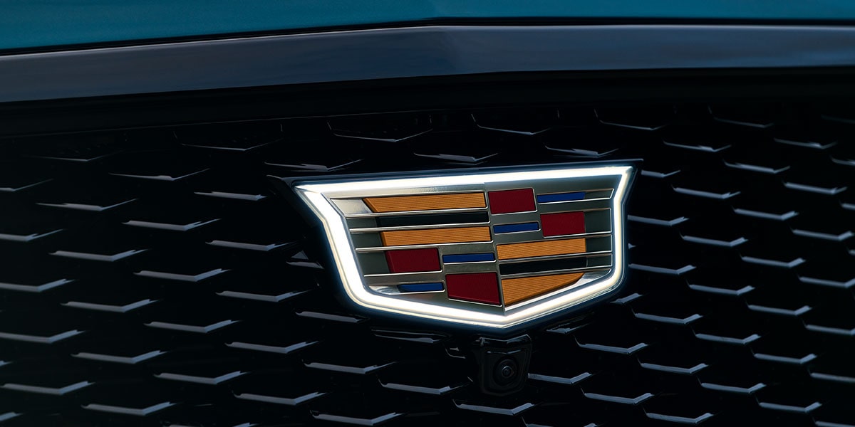 Gros plan sur l'emblème Cadillac illuminé, monté sur la calandre noire de l'Escalade 2027