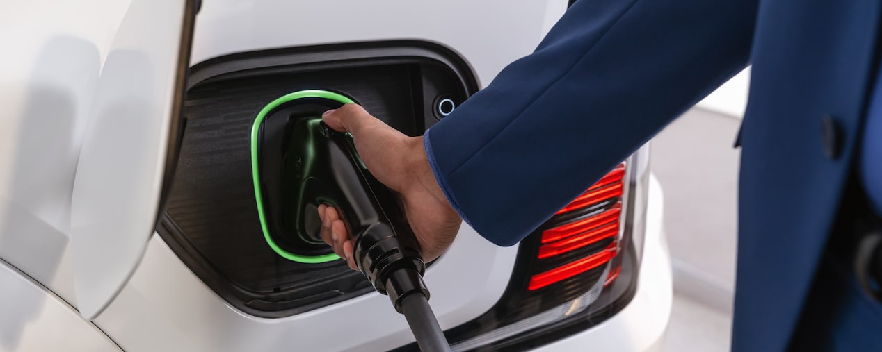 A person's hand charging the 2026 Cadillac Escalade IQL.