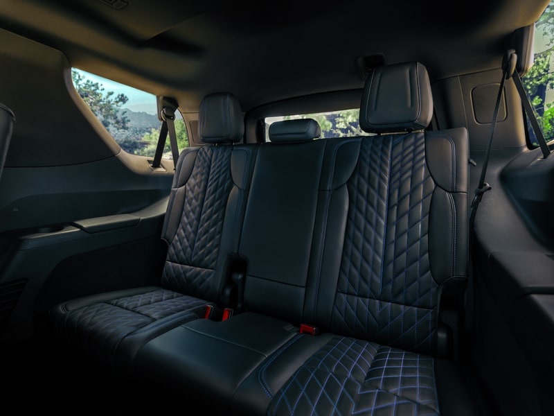 Une personne range des sacs et des valises dans le coffre du Cadillac Escalade IQL 2026.
