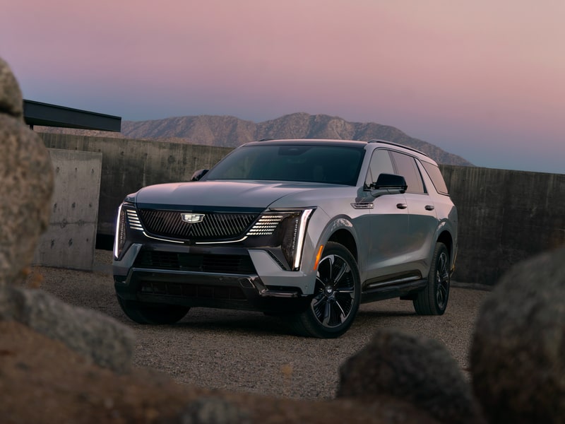 Vue latérale d’une personne qui tient le volant du Cadillac Escalade IQL 2026.