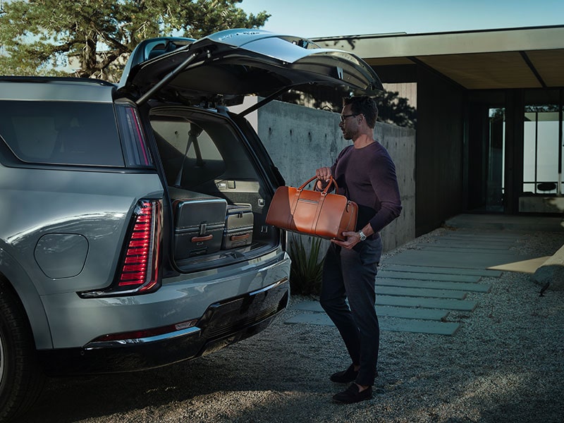 Une personne range des sacs et des valises dans le coffre du Cadillac Escalade IQL 2026.