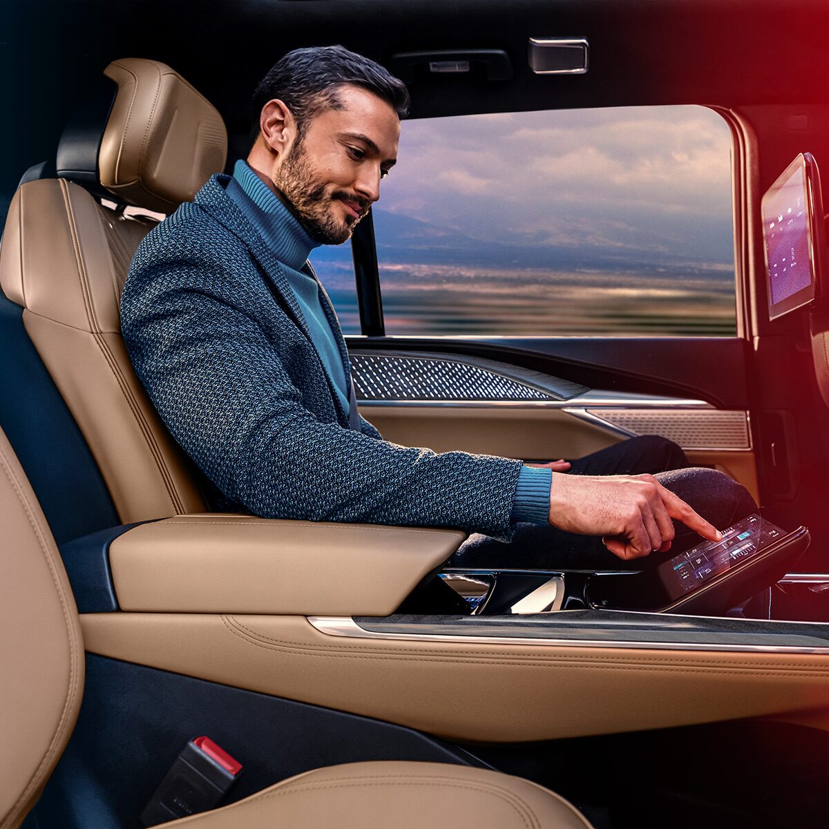 Une personne assise confortablement à la deuxième rangée du Cadillac Escalade IQL 2026 appuie sur un bouton dans un écran.