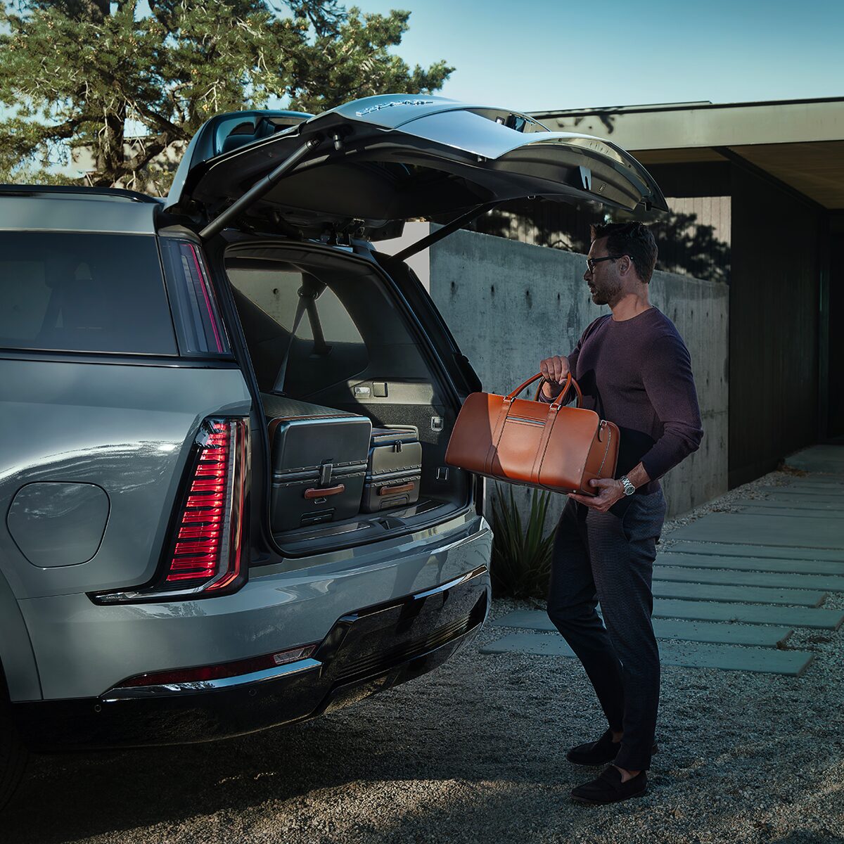 Une personne range des sacs dans le coffre du Cadillac Escalade IQL 2026.