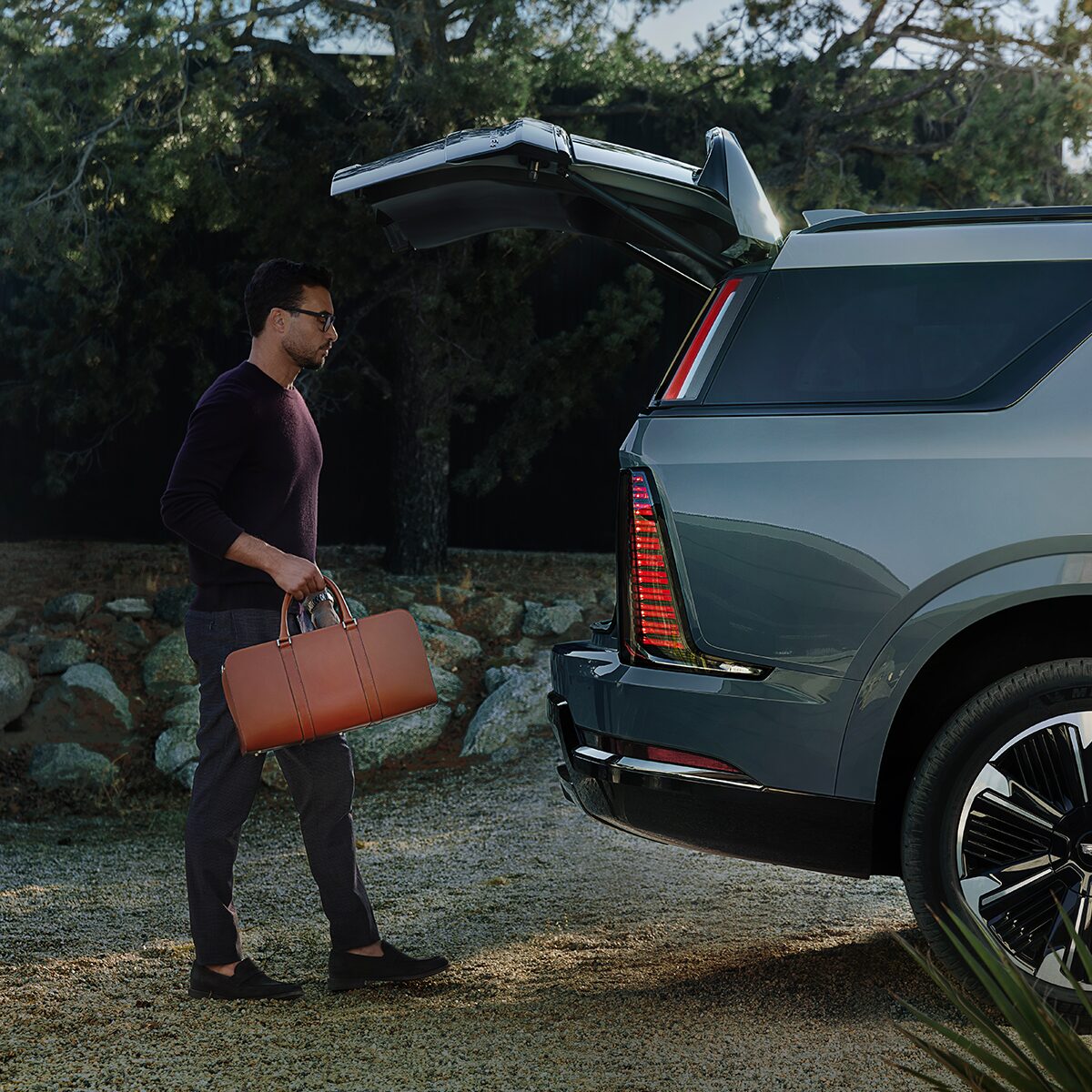Une personne range des articles dans le coffre du Cadillac Escalade IQL 2026.