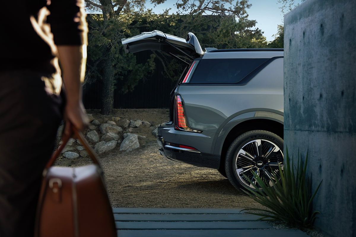 Une personne range des articles dans le coffre du Cadillac Escalade IQL 2026.
