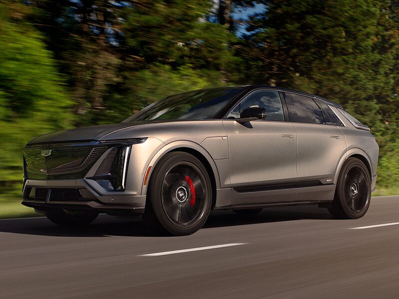The 2026 Cadillac LYRIQ-V driving fast on the road.