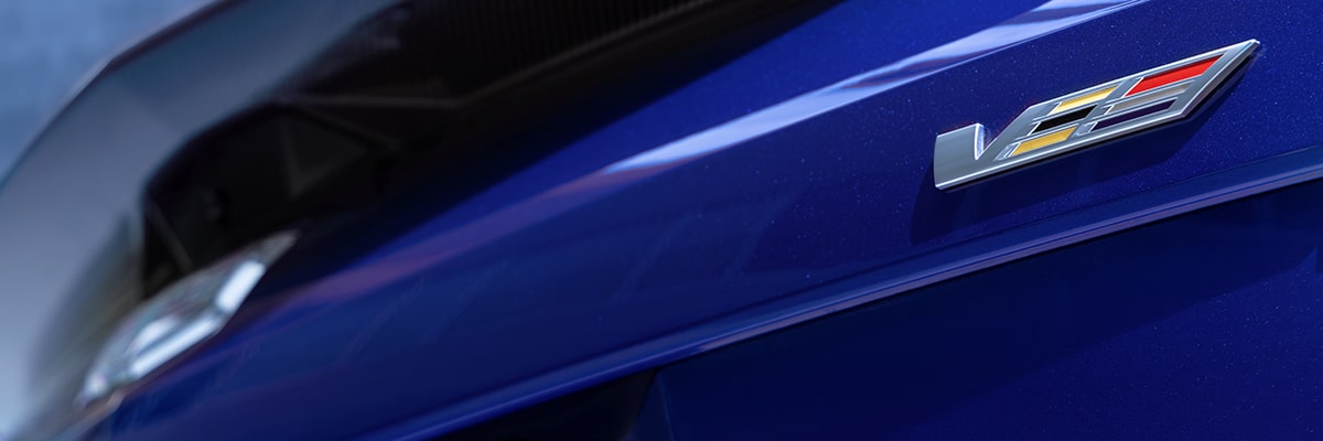 Close-up of V-Series badge on the front fender with carbon fiber detailing.