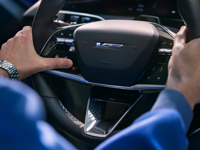 Driver’s hands on the Cadillac OPTIQ-V steering wheel.