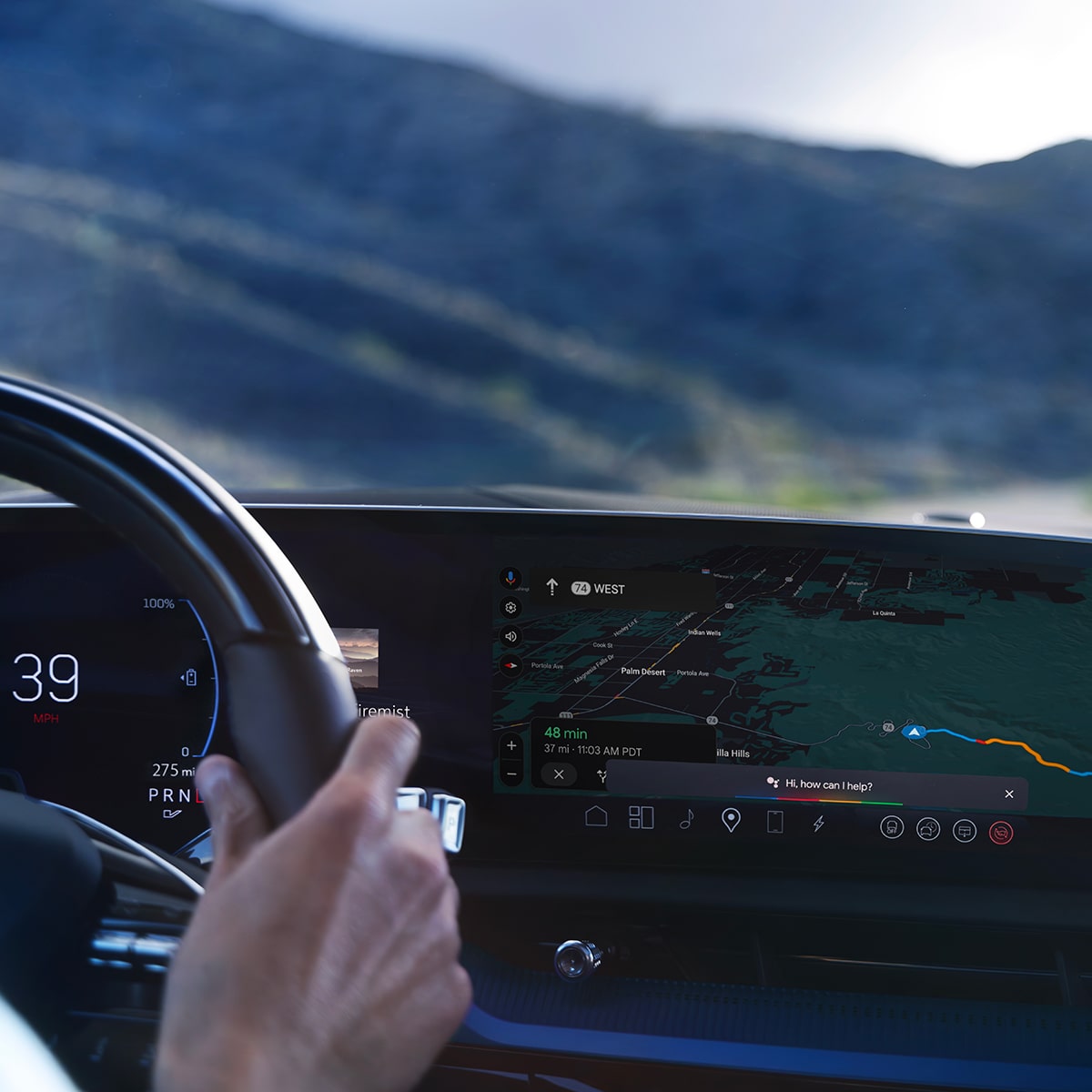 Driver adjusting infotainment controls while driving the OPTIQ-V.