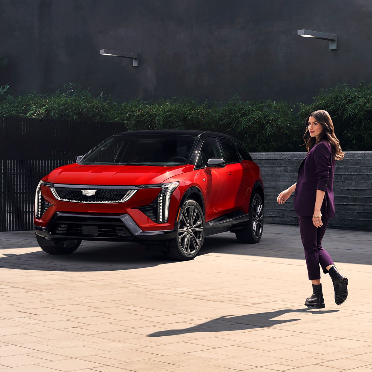 A person walking towards the 2026 Cadillac OPTIQ.