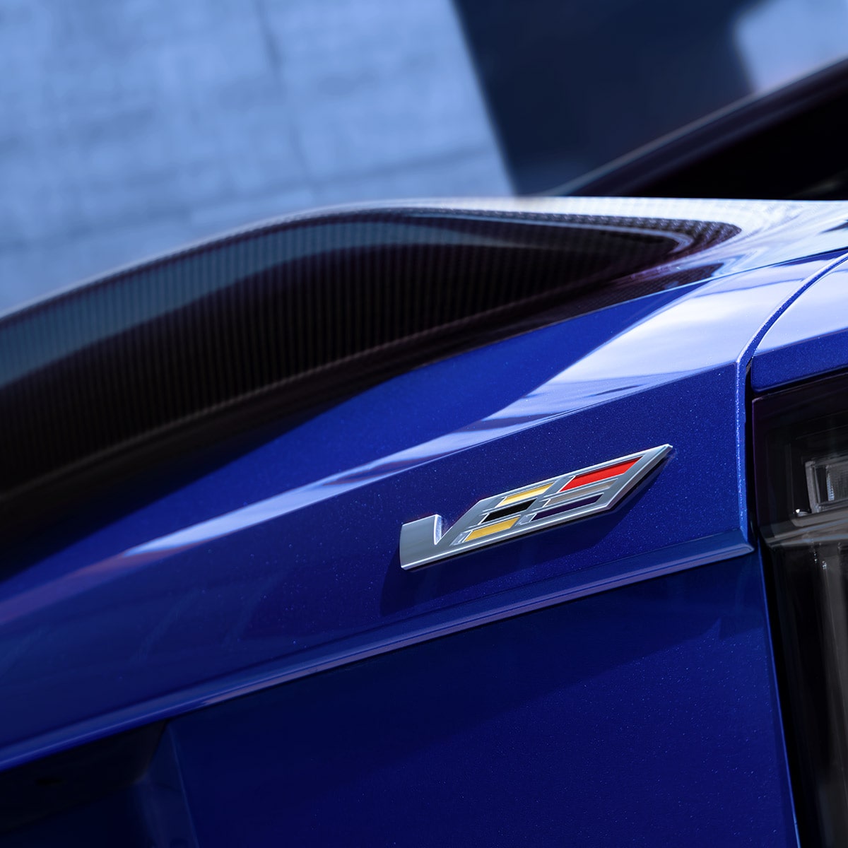 Close-up of V-Series badge on the front fender with carbon fiber detailing.