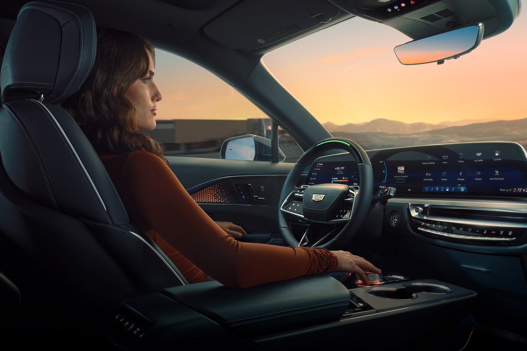 Driver seated in the 2027 Cadillac LYRIQ interior, viewing a wide curved digital display spanning the dashboard.