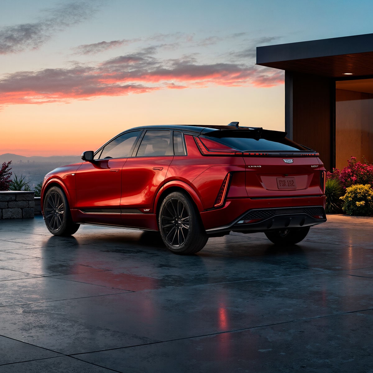 Back-side view of the 2027 Cadillac LYRIQ parked outside a modern home on a gloomy day.