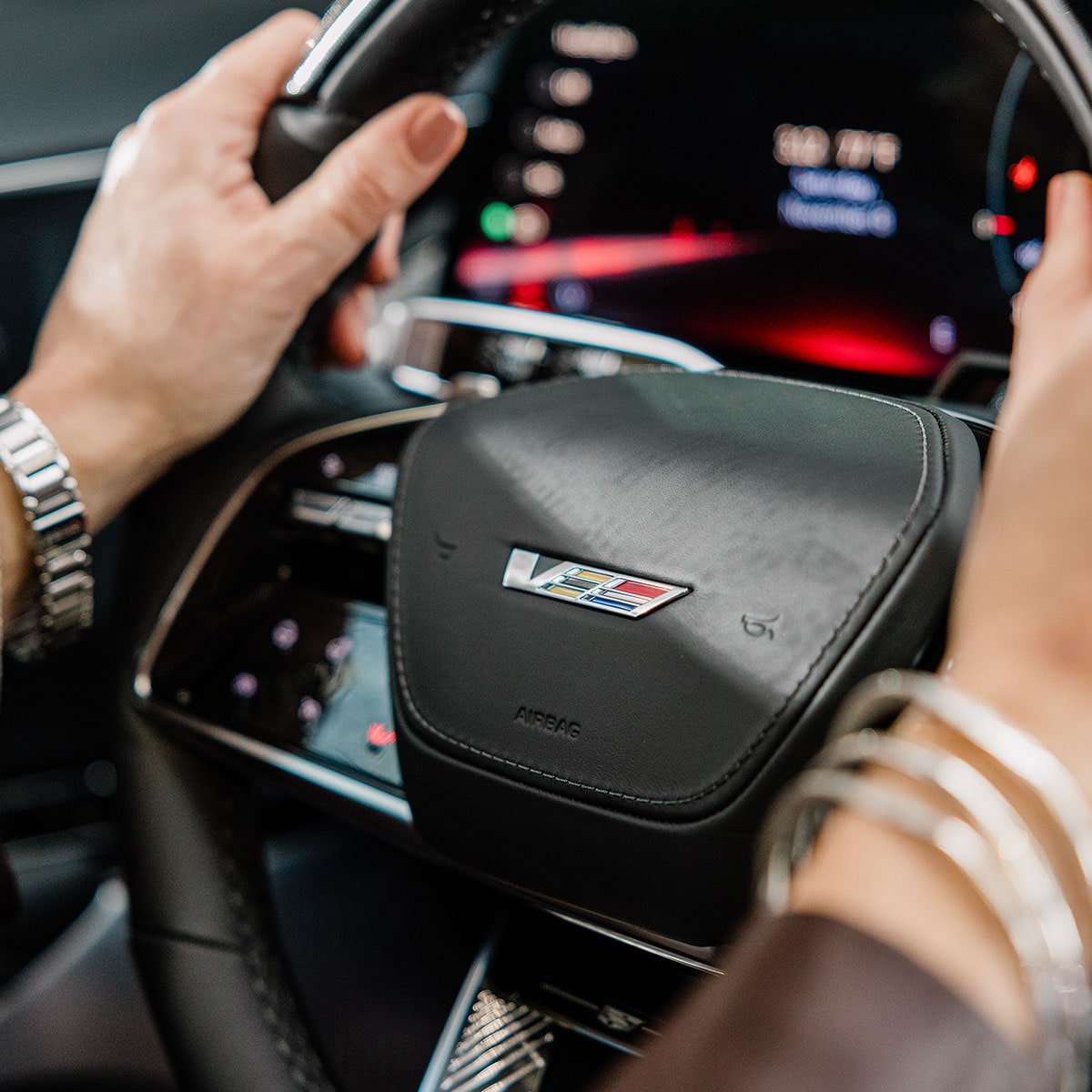 Close-up view of a hand on the steering wheel of the 2027 Cadillac LYRIQ.